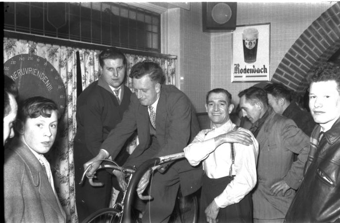 Demarck op fiets op rollen met supporters, Izegem 1957